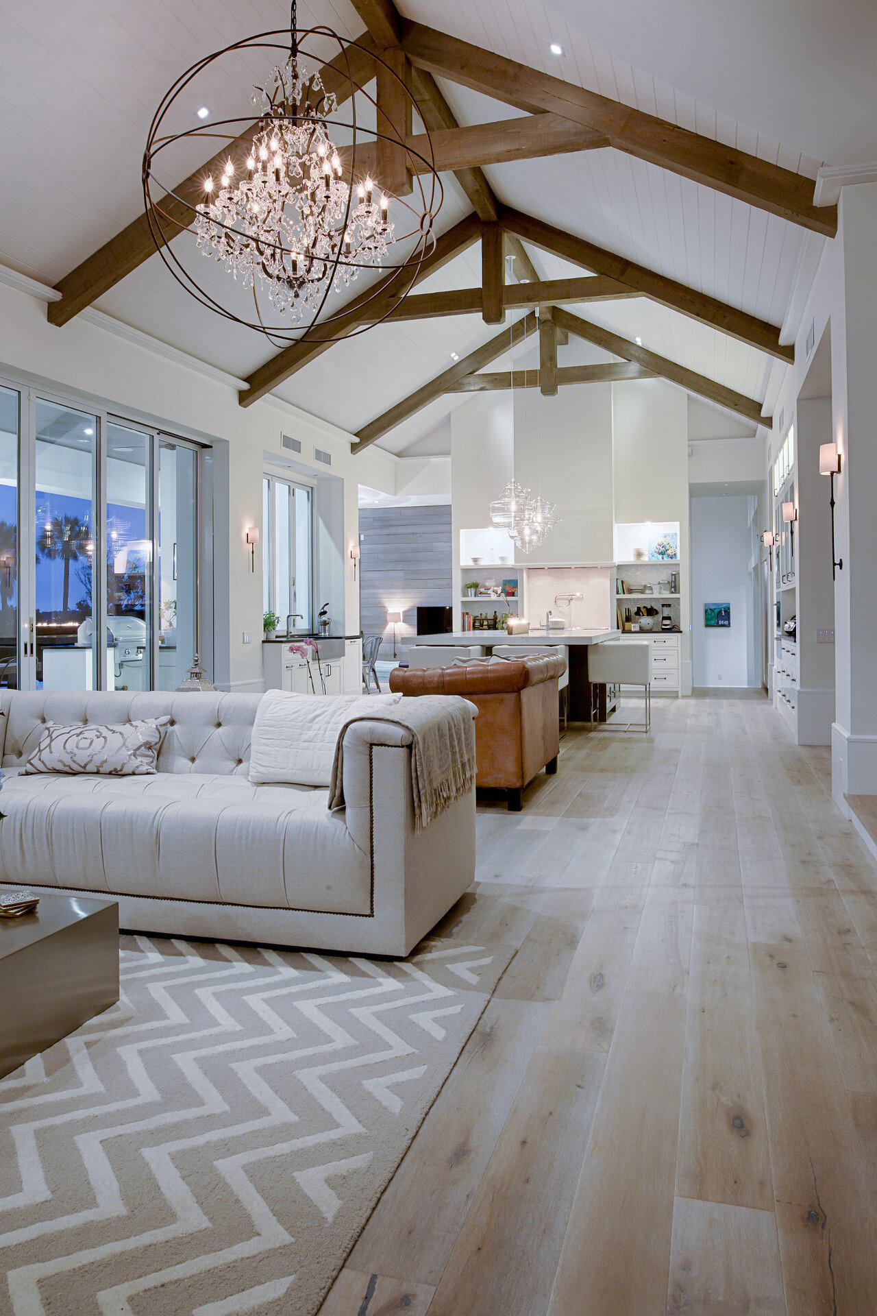 Layered lighting across a connected living room and kitchen in a custom Lutron installation