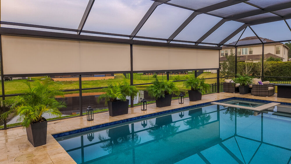 Screened pool enclosure with SunPro motorized shades over the pool and spa