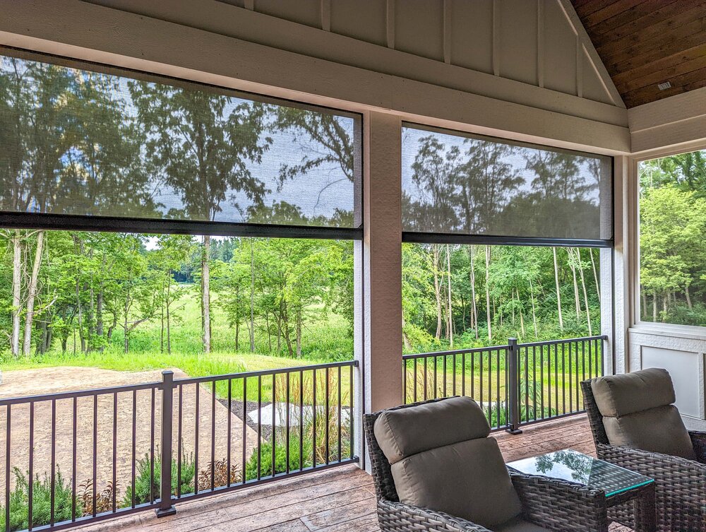 SunPro solar-screen mesh lowered on a porch, blocking sun and insects while keeping the view